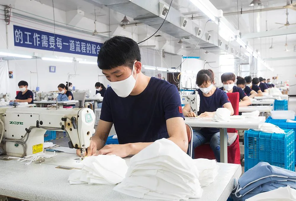 Team members sewing white hotel textile products