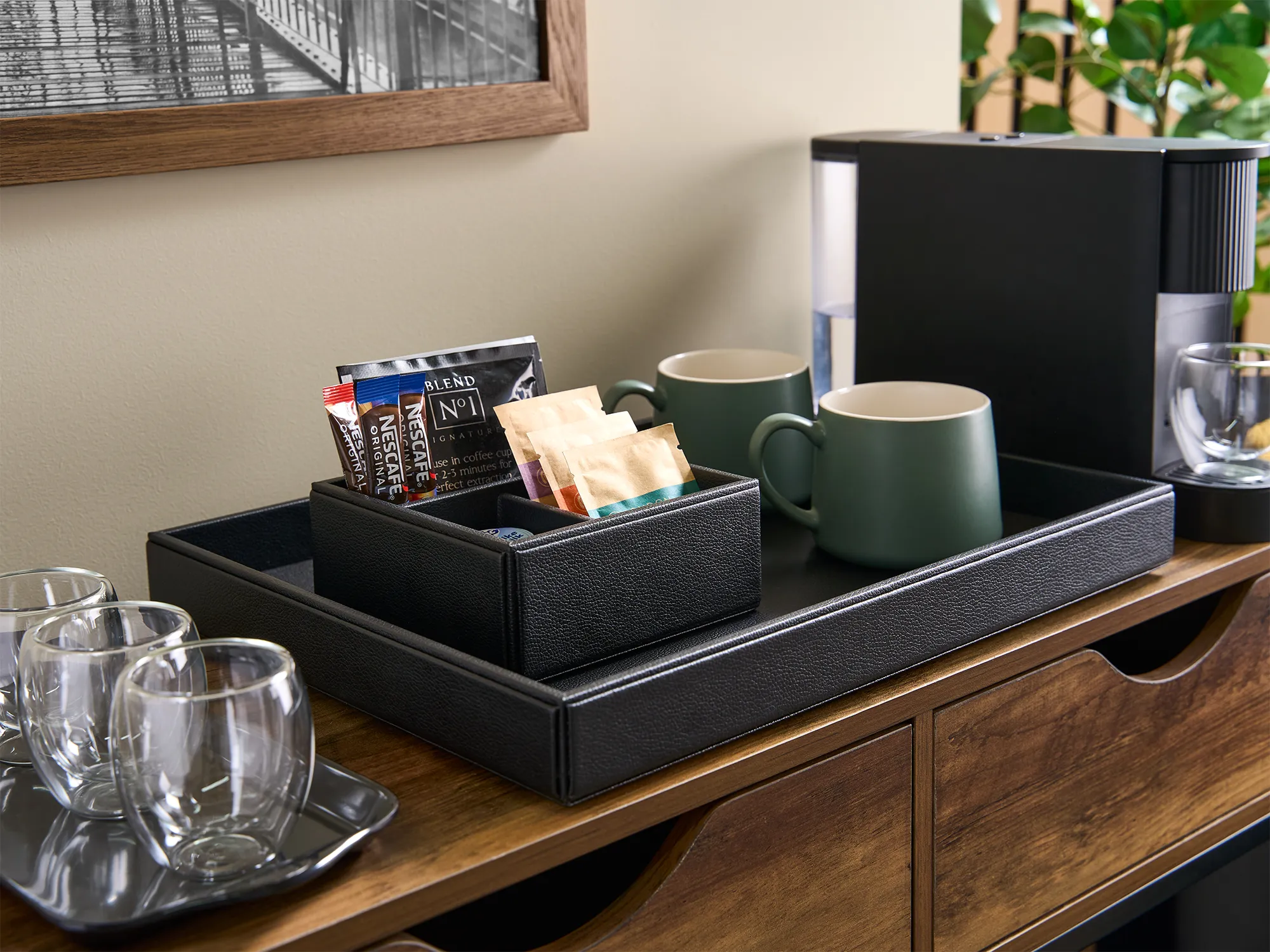 An organized in-room refreshment tray with coffee, cups and water
